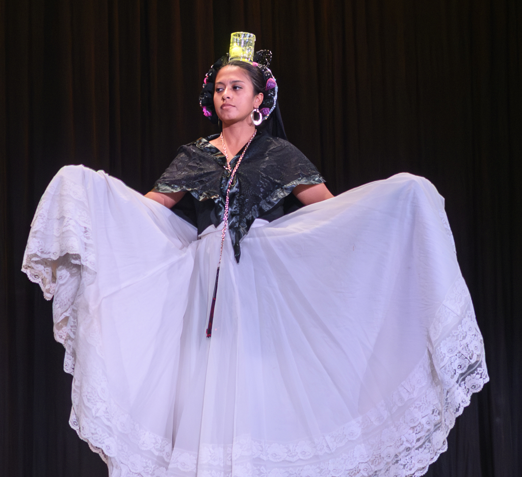 Hispanic Dancer with long white skirt and candle balanced on head for heritage assembly