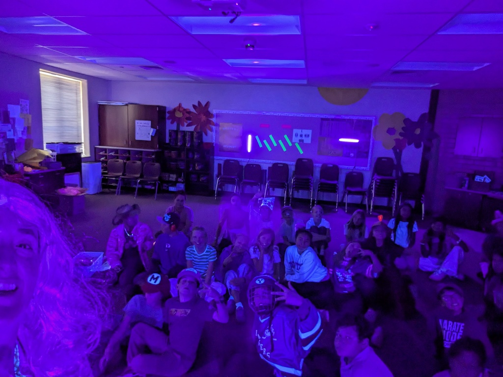 students posing for a picture in a black light