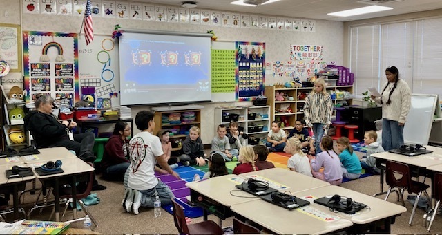 students sitting around the rug in their classroom