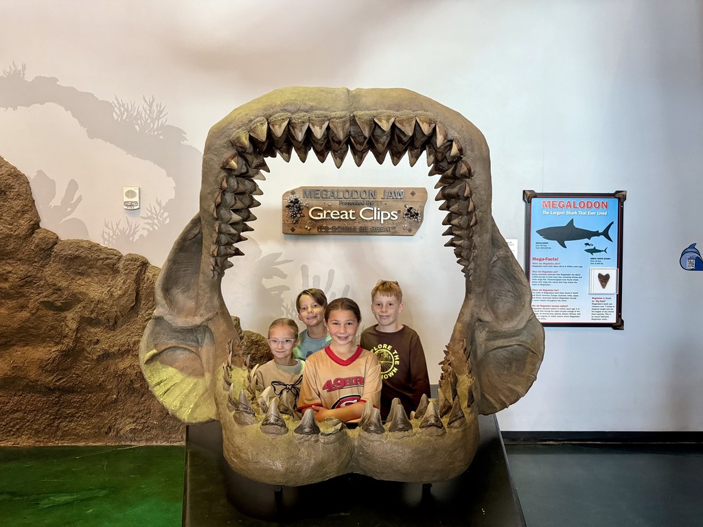 Students standing in a large fish jaw.