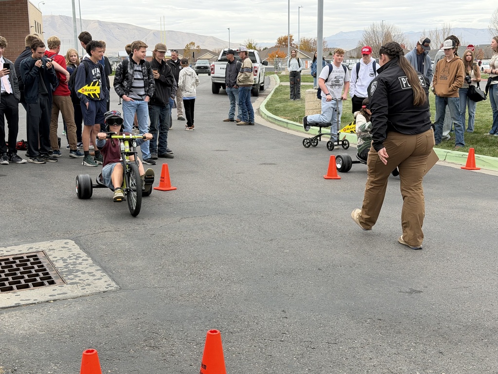 Pizza with the Police Lunchtime Activity- students riding bikes with drunk goggles
