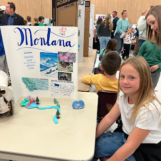 Student showing off state fair poster