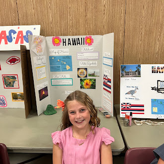 Student showing off state fair poster