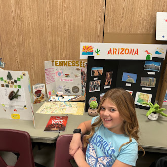 Student showing off state fair poster
