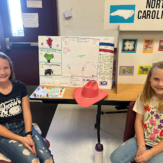 Student showing off state fair poster