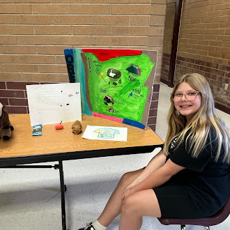 Student showing off state fair poster