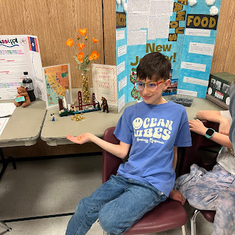 Student showing off state fair poster