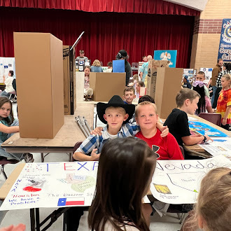 Student showing off state fair poster