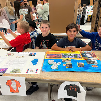 Student showing off state fair poster