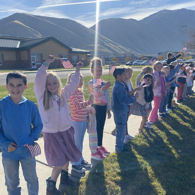 a line of kids waving American flags