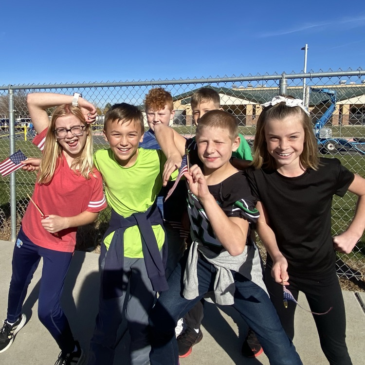 6 fifth graders holding flags and smiling