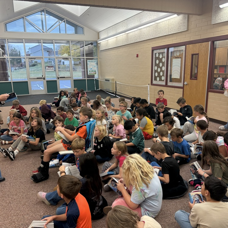 children sitting looking through dictionary