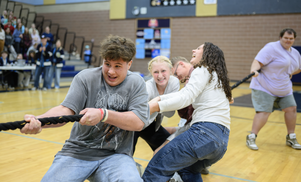 Students playing tug of war in the make a wish assembly