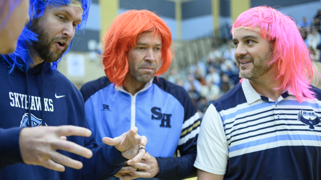 Teachers with wigs on for the "wig snatch game in the make a wish assembly