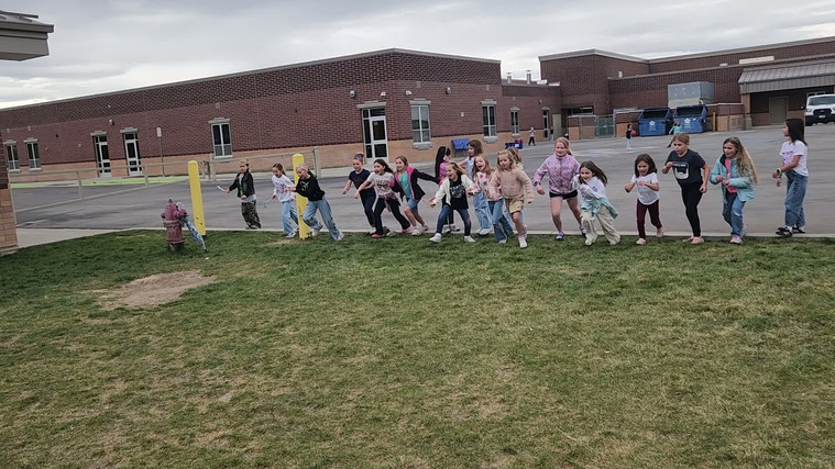 Students playing "Run and Scream" on the field.