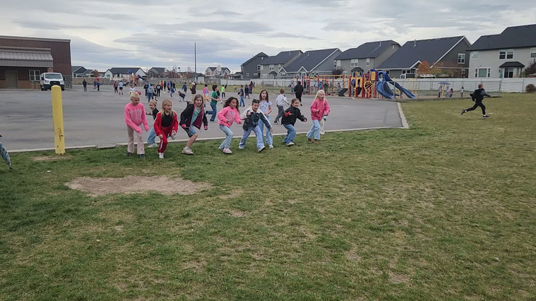 Students playing "Run and Scream" on the field.
