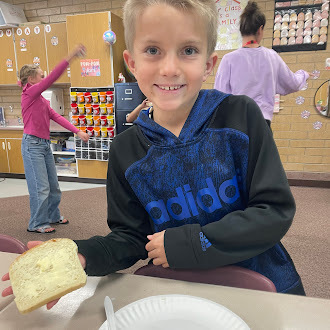 Students putting butter on bread