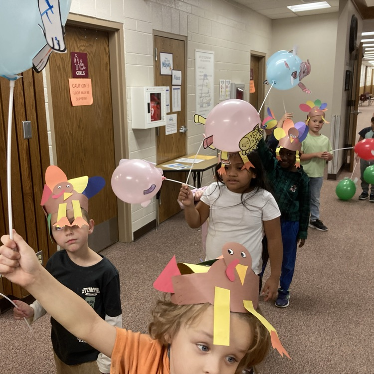 Students holding up their ballon creations walking the halls