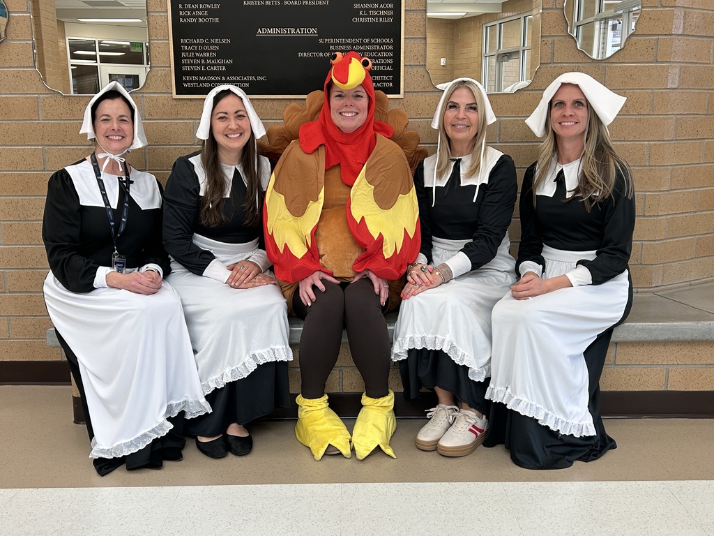 Maple Ridge office staff dressed up for Thanksgiving--4 pilgrim ladies and a turkey.
