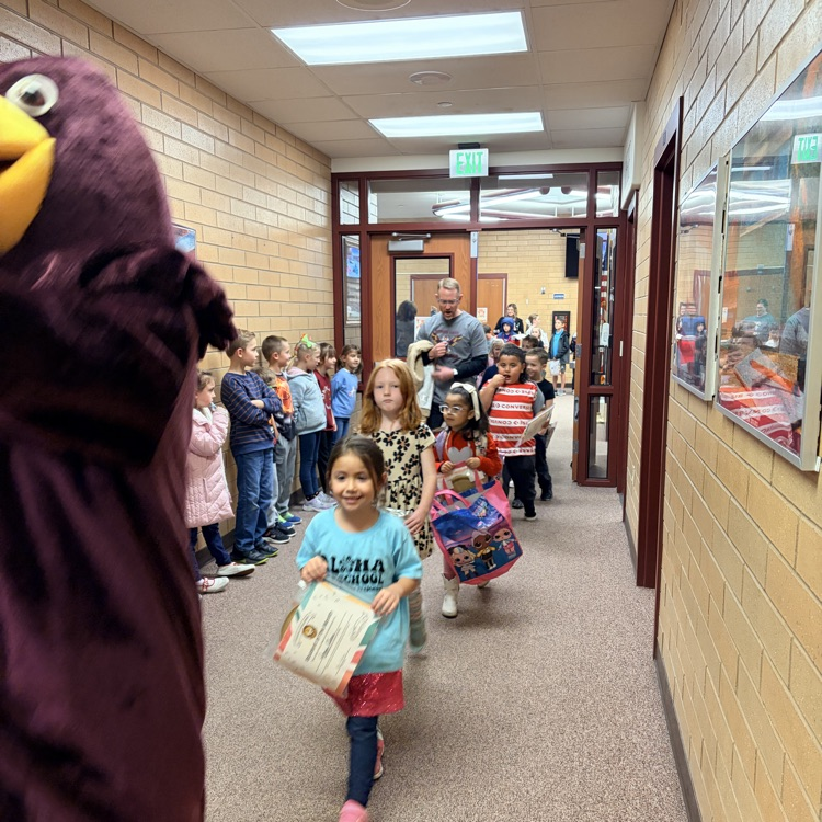 kindergarten students walking behind a masco