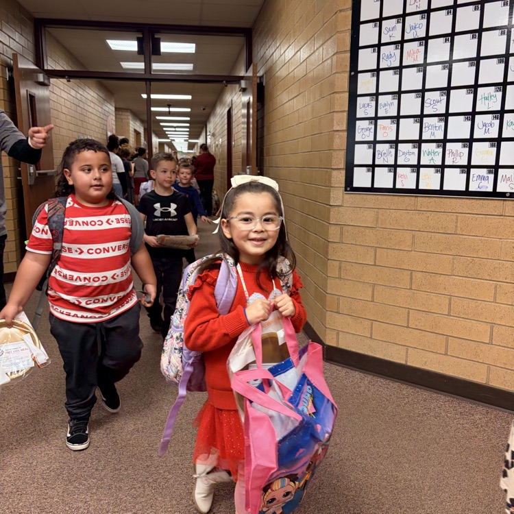 a girl wearing red smiling with two other kids behind her