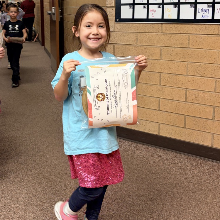 a girl smiling while holding her certificate