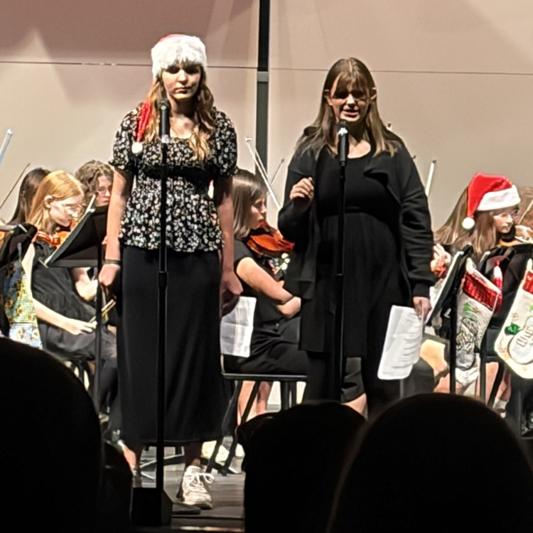 two girls narrating twas the night before Christmas while Orchestra plays