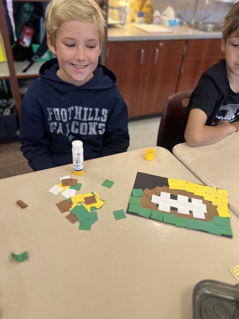 student posing with their artwork