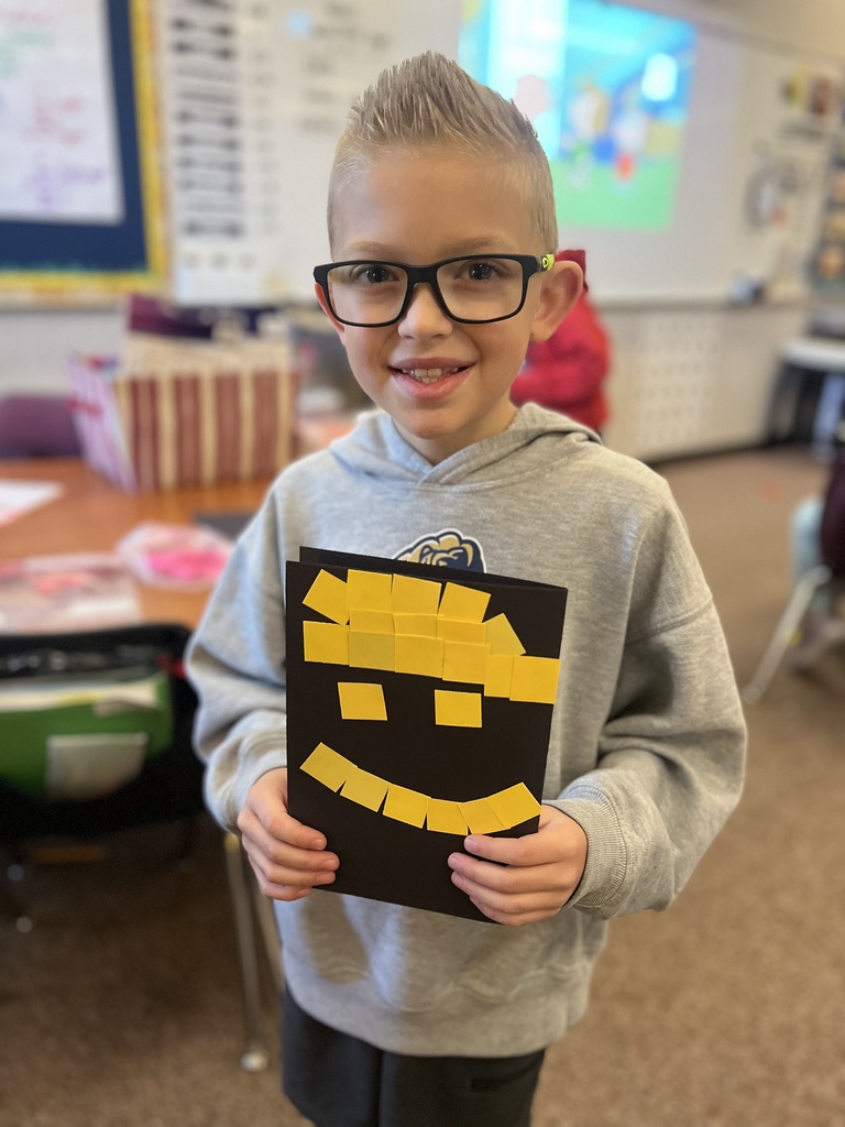 student posing with their artwork