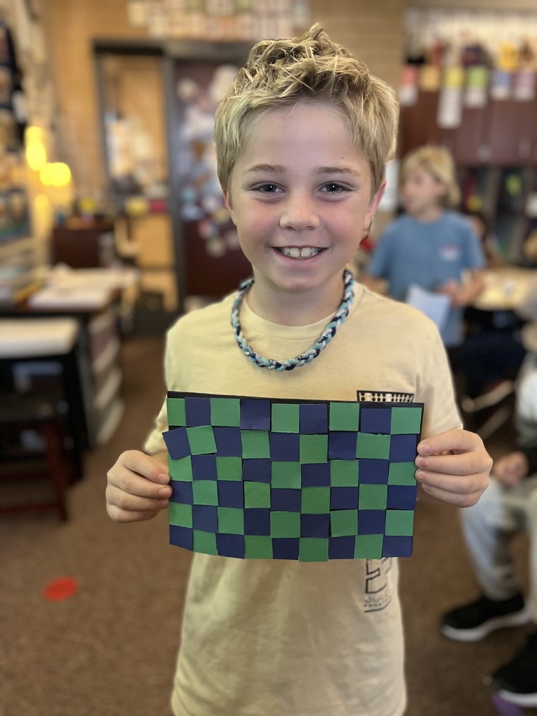 student posing with their artwork