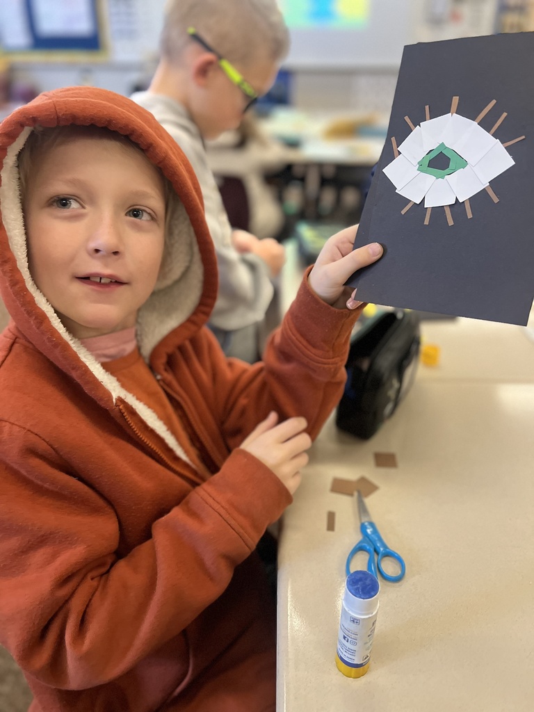 student posing with their artwork