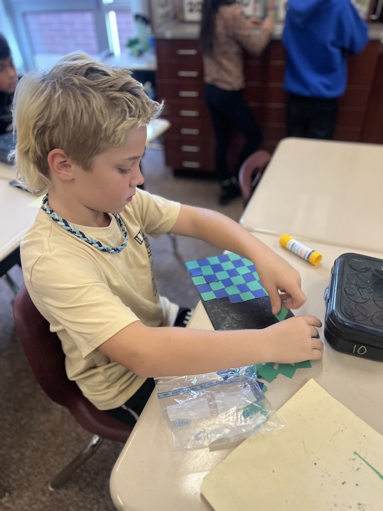 student posing with their artwork