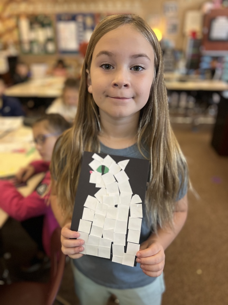 student posing with their artwork