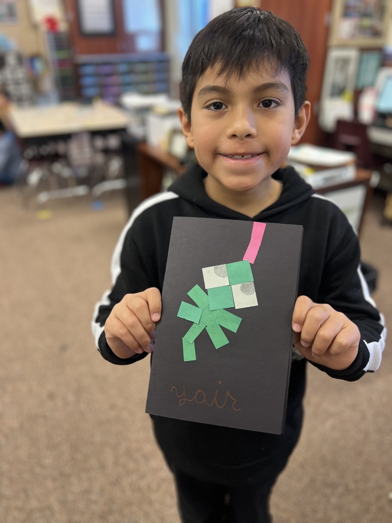 student posing with their artwork