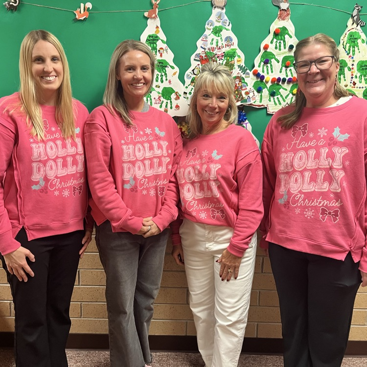 Teachers dressed in Holly Dolly Christmas sweatshirts.
