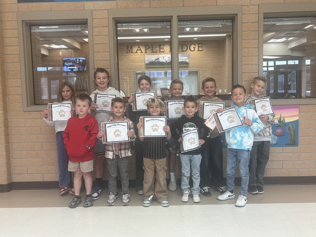 Students holding up their student of the month certificate.