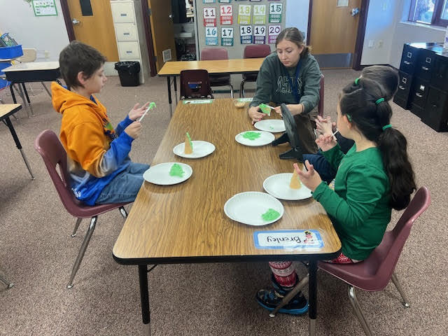 students adding icing to an ice cream cone