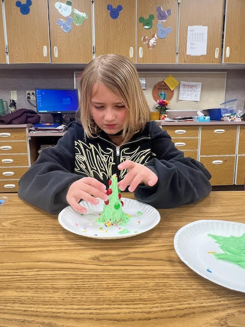 Student adding m&m's on an ice cream cone
