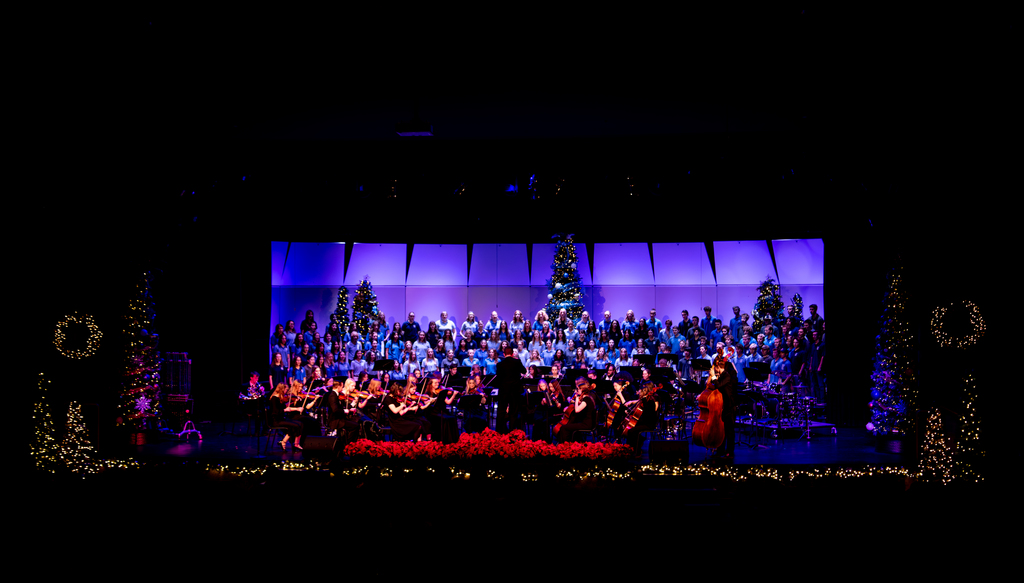 Fine arts Assembly- Choir and orchestra on stage with Christmas trees
