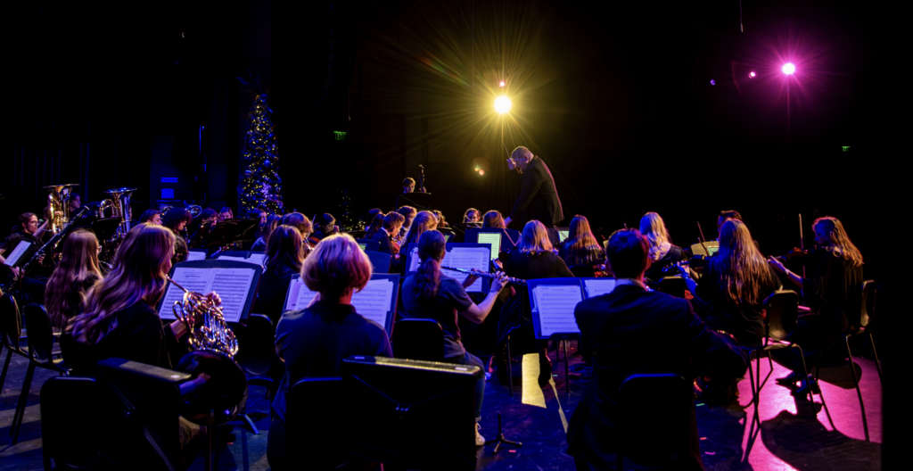 Fine arts Assembly- orchestra on stage with Christmas tree and lights