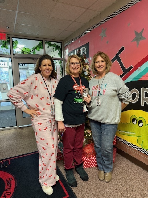 Teachers and staff standing in school wishing everyone a Merry Christmas.
