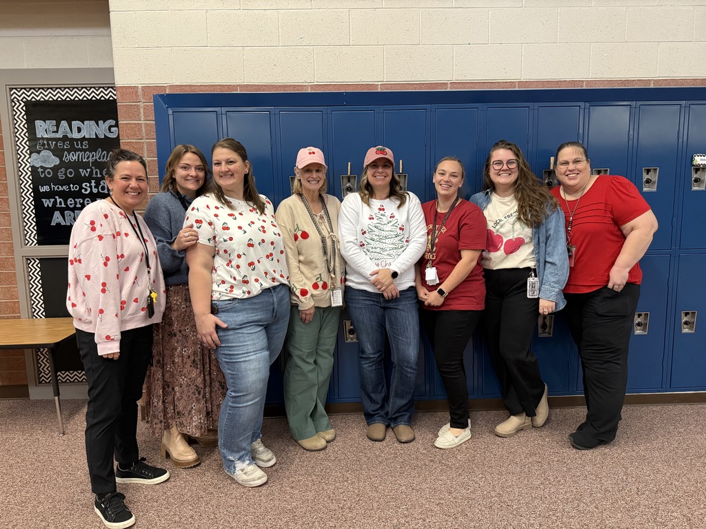 Teachers and staff standing in school wishing everyone a Merry Christmas.