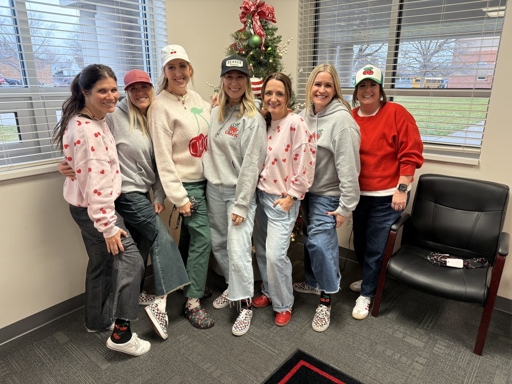 Teachers and staff standing in school wishing everyone a Merry Christmas.