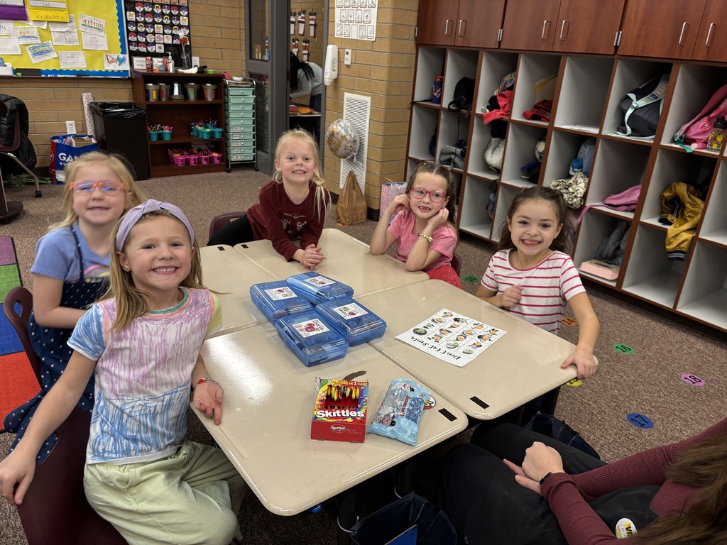 students posing at a group of desks