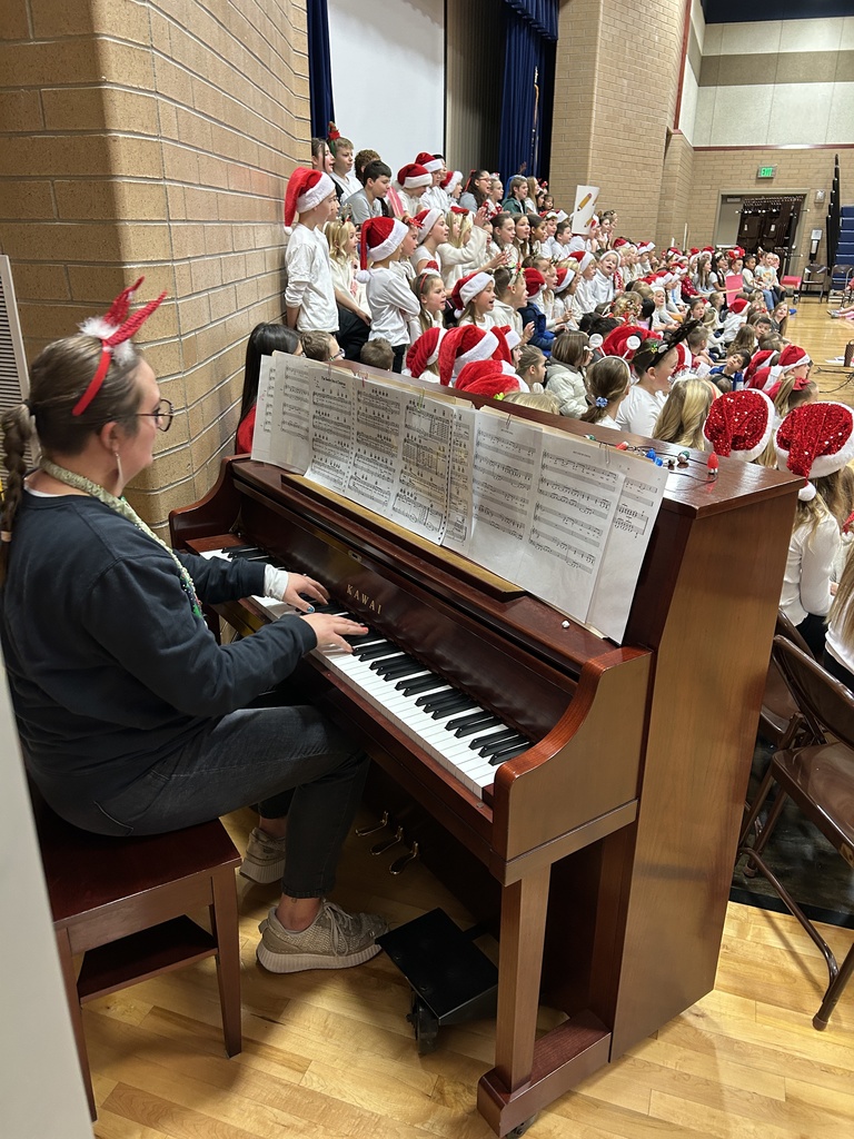 Mrs. Berbert playing the piano and the Christmas choir.