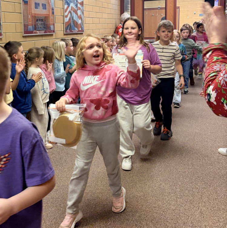 kids walking down the hall while other students cheer them on