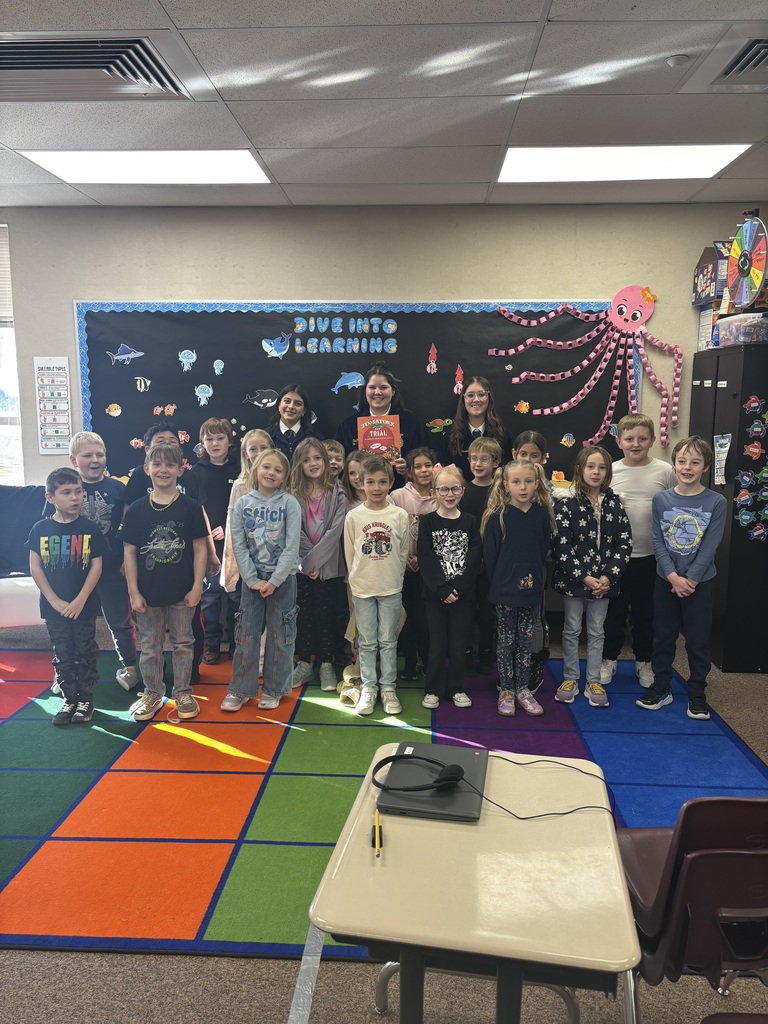 3 FFA students standing on the rug with a class of second graders standing in front of them