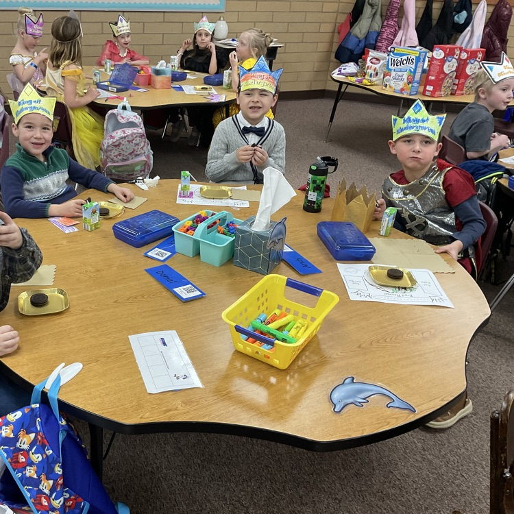 three boys sitting at their table eating Oreo