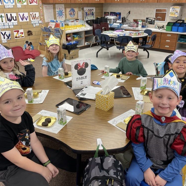 six kids sitting at their table and smiling