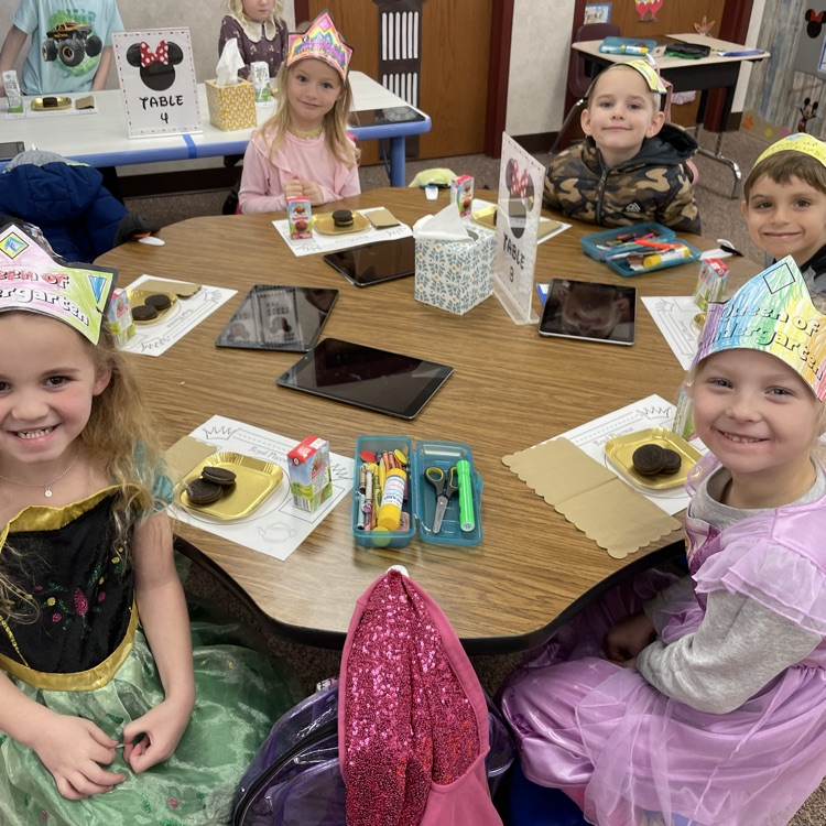five kids sitting at their table smiling